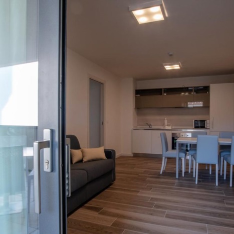 Aparthotel con cucina laccata, soggiorno componibile e divano letto. 